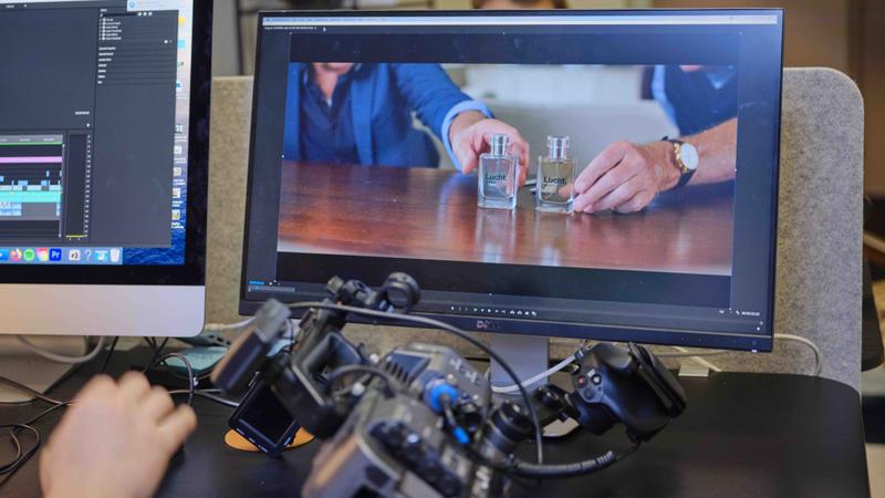 Montageplek met camera op bureau en scherm met videobeelden Videomontage aan een bureau met camera en een computerscherm waarop videobeelden worden bewerkt