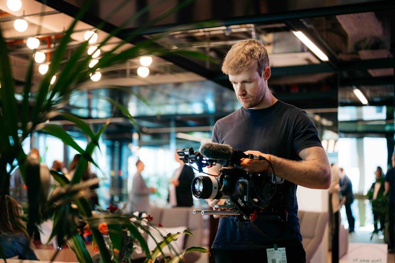 Videograaf maakt sfeerbeelden in event ruimte Videograaf met camera