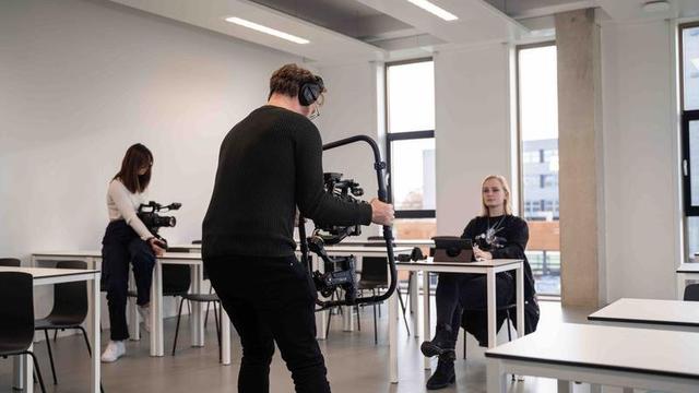 Cameraploeg tijdens filmopnames Cameraploeg filmt een student tijdens opleidingsvideo