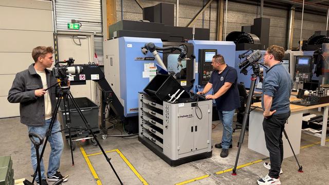 Videografen filmen een machine Twee videografen filmen een machine bij Waboplast